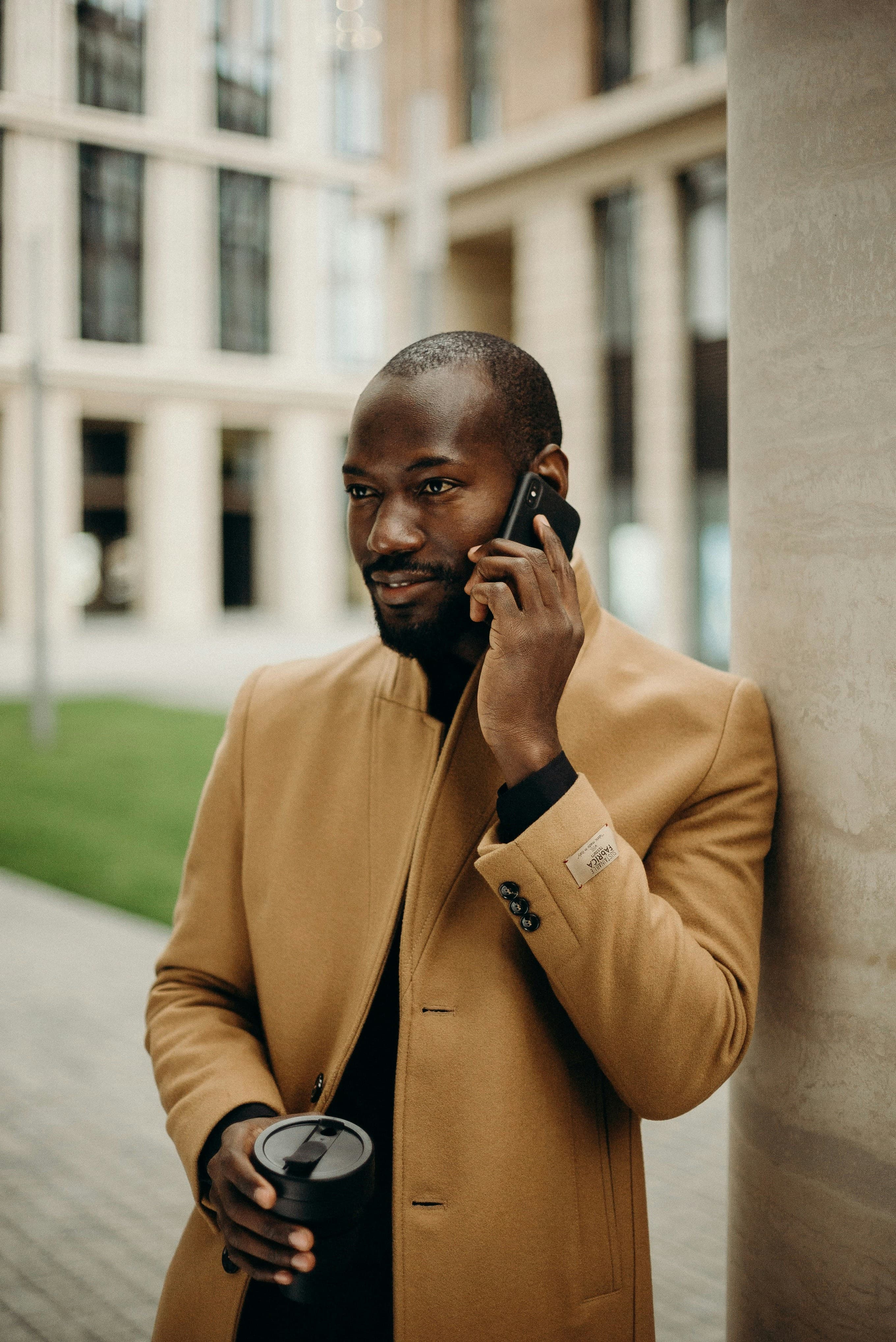 Man in camel coat on phone